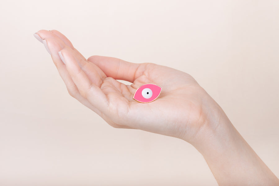 Hand painted enamel and gold plated pink eye ring worn on finger