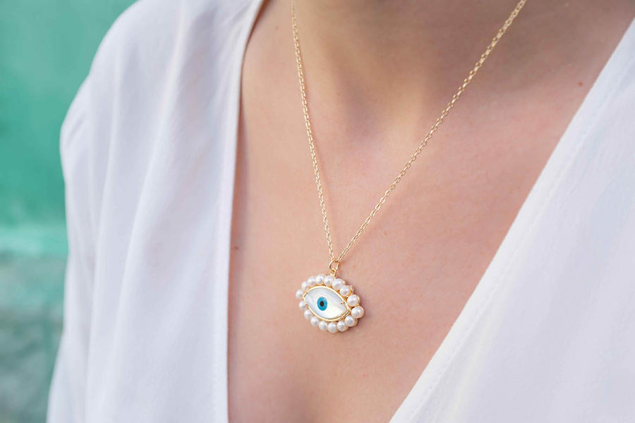 Gold plated mother of pearl eye necklace with pearls worn on neck