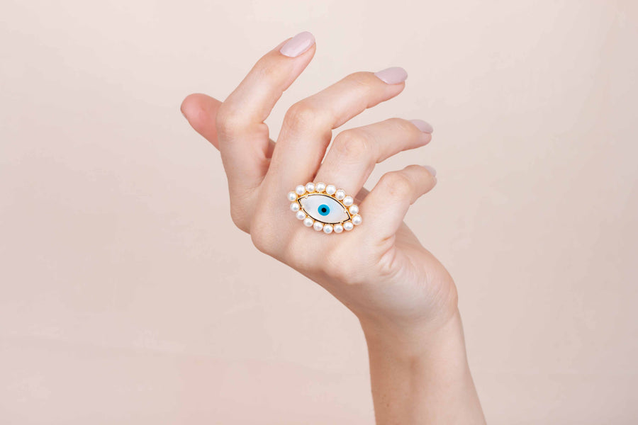 Gold plated mother of pearl eye ring with pearls worn on finger