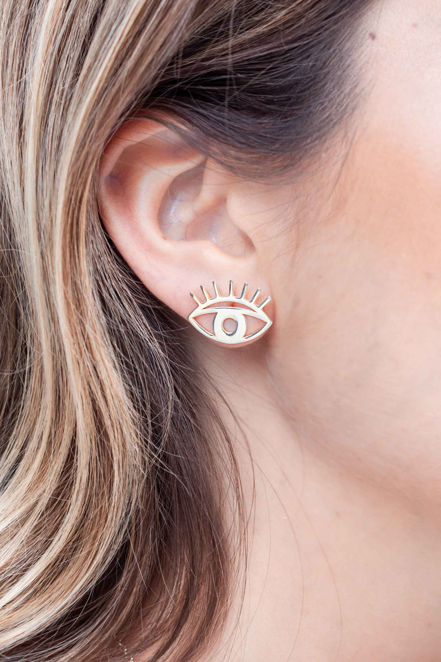 Gold plated abstract eye studs worn on ear 