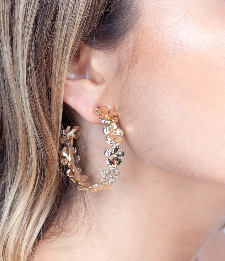 Gold plated flower hoop worn on ear